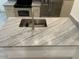 Close-up of granite countertop and stainless steel sink with modern faucet at 8653 E Royal Palm Rd # 1006, Scottsdale, AZ 85258