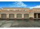 Street view of the residential garages each with arched entryways and a red-tiled roof at 8653 E Royal Palm Rd # 1006, Scottsdale, AZ 85258