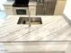 Granite kitchen island top featuring a stainless steel sink and faucet at 8653 E Royal Palm Rd # 1006, Scottsdale, AZ 85258