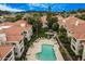 Aerial view of a community with a pool, lounge chairs, fountain, grass, and red-tiled roofs at 8653 E Royal Palm Rd # 1006, Scottsdale, AZ 85258