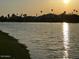 Tranquil lake at sunset, reflecting the sun's golden light, framed by trees and distant mountains at 8653 E Royal Palm Rd # 1006, Scottsdale, AZ 85258