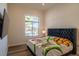 Bright bedroom featuring a large window, wood flooring, and decorative patterned bedding at 9440 N 57Th St, Paradise Valley, AZ 85253