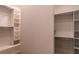 Clean walk-in closet with custom shelving and hanging rods offer plenty of organized space at 9440 N 57Th St, Paradise Valley, AZ 85253