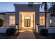 Eye-catching front entrance with a modern door framed by an illuminated portico and lush landscaping at 9440 N 57Th St, Paradise Valley, AZ 85253