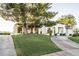 Beautiful exterior of a modern home with lush lawn, mature trees, and a circular driveway at 9440 N 57Th St, Paradise Valley, AZ 85253