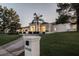 Elegant white home with a well-manicured front yard and palm trees lining the driveway at 9440 N 57Th St, Paradise Valley, AZ 85253