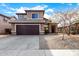 Two story home with a large two car garage, rock accents, and a well manicured front yard at 9545 W Williams St, Tolleson, AZ 85353