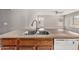 Close-up of a kitchen island featuring a dual sink, faucet, and oak cabinets at 9545 W Williams St, Tolleson, AZ 85353