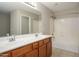 Bright bathroom features a double sink vanity, large mirror, and shower-tub combo at 10219 E Isleta Ave, Mesa, AZ 85209