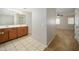 Bathroom with a double vanity sink with tile floors and access to bedroom with carpet at 10219 E Isleta Ave, Mesa, AZ 85209