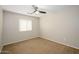 Comfortable carpeted bedroom with a ceiling fan, neutral walls, and natural light from a window at 10219 E Isleta Ave, Mesa, AZ 85209