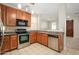 Well-lit kitchen features stainless steel appliances, tile floors and granite countertops at 10219 E Isleta Ave, Mesa, AZ 85209