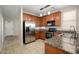 Well-equipped kitchen featuring stainless steel appliances, granite countertops, wood cabinetry, and tile flooring at 10219 E Isleta Ave, Mesa, AZ 85209