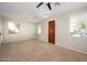 Bright living room with neutral carpet, a ceiling fan, and multiple windows for ample natural light at 10219 E Isleta Ave, Mesa, AZ 85209