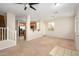 Open living area with carpet flooring flowing into the kitchen featuring wood cabinets and stainless steel appliances at 10219 E Isleta Ave, Mesa, AZ 85209