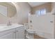 Bright bathroom featuring a vanity with a round mirror and a shower-tub combination at 10392 W Deanne Dr, Sun City, AZ 85351