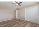 Bedroom featuring wood floors, a ceiling fan, and a large closet at 10392 W Deanne Dr, Sun City, AZ 85351