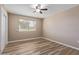 Neutral bedroom with wood floors, a ceiling fan, and a bright window at 10392 W Deanne Dr, Sun City, AZ 85351