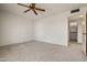 Large primary bedroom with ceiling fan, neutral carpet and ensuite bathroom at 10509 W Oak Ridge Dr, Sun City, AZ 85351