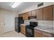 Charming kitchen featuring wood cabinets, granite counters, and black appliances at 10509 W Oak Ridge Dr, Sun City, AZ 85351