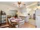 Inviting dining area featuring a ceiling fan, comfortable seating, and seamless flow into kitchen and living area at 10611 W Camelot Cir, Sun City, AZ 85351