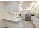 Bright kitchen with white cabinets, stainless steel refrigerator, and ample counter space at 10611 W Camelot Cir, Sun City, AZ 85351