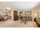 A bright living room featuring classic furnishings, a skylight, and seamless flow to dining area at 10611 W Camelot Cir, Sun City, AZ 85351