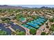 Scenic aerial view of a community featuring tennis courts, a pool, lush landscaping, and beautiful mountain views at 11256 E Palomino Rd, Scottsdale, AZ 85259