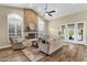 Inviting living room features a stone fireplace, vaulted ceilings, hardwood floors, and natural light from large windows at 11256 E Palomino Rd, Scottsdale, AZ 85259