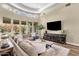 Cozy living room featuring wood floors, large windows, and a comfortable sectional sofa at 11256 E Palomino Rd, Scottsdale, AZ 85259