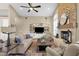 Inviting living room with a stone fireplace, hardwood floors, built in cabinets and vaulted ceilings with a ceiling fan at 11256 E Palomino Rd, Scottsdale, AZ 85259