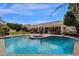 Backyard featuring a sparkling pool with a baja step and lush landscaping at 11256 E Palomino Rd, Scottsdale, AZ 85259