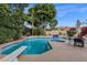 Beautiful backyard pool with a built-in spa, waterfall feature, and well-manicured landscaping at 11256 E Palomino Rd, Scottsdale, AZ 85259