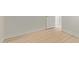 An empty bedroom featuring wood-look floors, white baseboards, and a white painted door at 113 W Rawhide Ave, Gilbert, AZ 85233