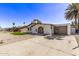 Street view of a single-story stucco home featuring an arched entryway, low-maintenance landscaping, and a detached garage at 113 W Rawhide Ave, Gilbert, AZ 85233