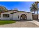 Charming home featuring an arched entryway, low-maintenance landscaping, and a tan stucco exterior with a detached garage at 113 W Rawhide Ave, Gilbert, AZ 85233