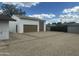 Large, detached garage with a double door, a single door, gravel parking area and partial privacy fence at 113 W Rawhide Ave, Gilbert, AZ 85233