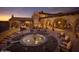 Outdoor living space featuring a water fountain, desert landscaping, fireplace, and ample seating at 12129 W Desert Mirage Dr, Peoria, AZ 85383