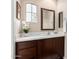 Powder room with white countertop, dark cabinets, and decorative mirror at 12129 W Desert Mirage Dr, Peoria, AZ 85383