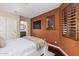 Bedroom with warm-toned walls, rich wood floors, and plantation shutters at 12129 W Desert Mirage Dr, Peoria, AZ 85383