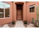 Welcoming entryway with a wooden front door, potted plants, and stylish decor at 12129 W Desert Mirage Dr, Peoria, AZ 85383