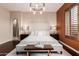 Stunning main bedroom featuring a king bed, dark wood floors, and an elegant chandelier lighting at 12129 W Desert Mirage Dr, Peoria, AZ 85383