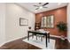 Warm, naturally-lit office featuring rich hardwood floors, a work desk, and a ceiling fan with light at 12129 W Desert Mirage Dr, Peoria, AZ 85383