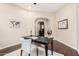 Bright home office with hardwood floors, neutral walls, a work desk, and an arched entryway at 12129 W Desert Mirage Dr, Peoria, AZ 85383