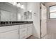 Modern bathroom features white cabinets, black granite countertop and double sinks and leads to the walk-in closet at 13729 E Rancho Laredo Dr, Scottsdale, AZ 85262