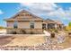 Inviting single-story home featuring desert landscaping with decorative stone accents and a well-kept lawn at 13729 E Rancho Laredo Dr, Scottsdale, AZ 85262