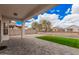 Inviting covered back patio with paver flooring, opening to a well-maintained yard with green grass at 1434 W Brangus Way, San Tan Valley, AZ 85143