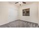 Neutral bedroom showcasing a ceiling fan, window with blinds, and a closet with sliding doors at 1434 W Brangus Way, San Tan Valley, AZ 85143