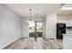 Dining area with wood-style flooring, a modern chandelier, and sliding glass door to the backyard at 1434 W Brangus Way, San Tan Valley, AZ 85143