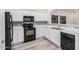 Contemporary kitchen featuring sleek black appliances, bright white cabinets, and wood-style flooring at 1434 W Brangus Way, San Tan Valley, AZ 85143